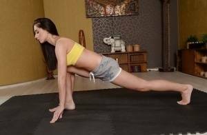 Cute brunette babe Aruna Aghora doing yoga in shorts and bare feet on modelies.com