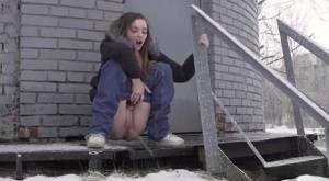 White girl pulls down her jeans to pee in the snow behind a building on modelies.com