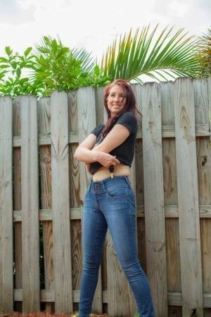 Hot redhead Andy Adams loses her t-shirt & jeans in the yard to pose naked on modelies.com