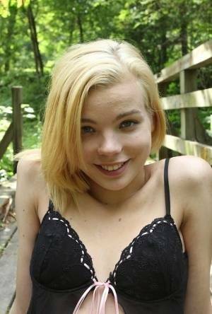 Cute teen amateur Sophia Kitten posing in nude in knee high socks in woods on modelies.com