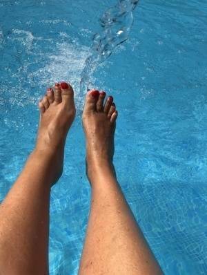 Mature woman Sweet Susi dips her painted toenails into a swimming pool on modelies.com