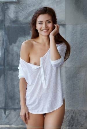 Petite teen divests herself of a white shirt to pose nude in and out of a pool on modelies.com