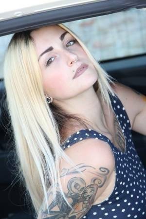 Tattooed girl Medusa Blonde shows her bare feet and ass while in a car on modelies.com