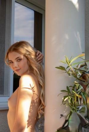 Young blonde Chanel Fenn shows her sexy ass while getting naked in a garden on modelies.com