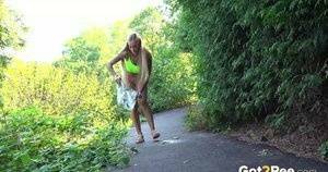 Blonde teen Daisy Lee takes a piss on a paved path through the woods on modelies.com
