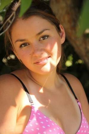 Petite amateur Allie Haze shows her tan lined body in the shade of a tree on modelies.com