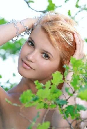 Adorable redhead Violla A displays her naked teen body atop a rock outdoors on modelies.com