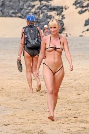 Hot blonde removes a skimpy bikini during a visit to a public beach on modelies.com
