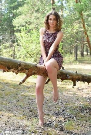 Nice young girl Ari gets completely naked while in a forested area on modelies.com